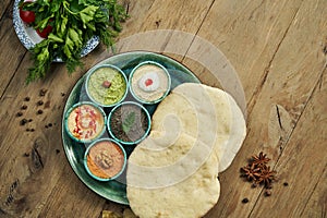 Classic eastern snacks with pita - meze. Set in small bowl - Hummus, hot pepper paste often with walnuts, yogurt, eggplant paste