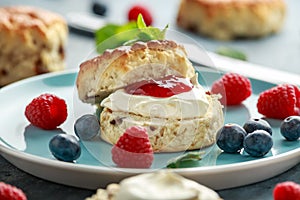 Classic English scones with clotted cream, strawberries jam and other fruit photo