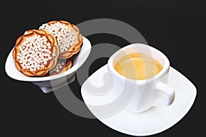 Classic espresso in white cup with homemade cake on black background. Selective focus.