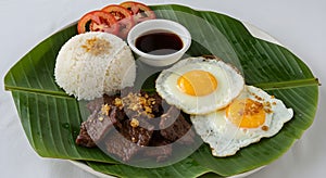 A Classic Filipino Tapsilog Breakfast with Beef Tapa and Fried Eggs photo