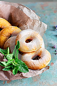 Classic fresh donuts with sugar icing and lavender flowers and mint leaves