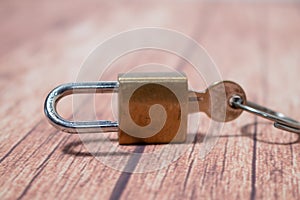 Classic golden bronze padlock with keys on a wooden background. Concept of security photo