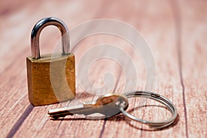 Classic golden bronze padlock with keys on a wooden background. Concept of security photo
