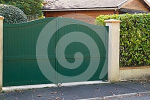 Classic green dark door metal home gate at entrance of house suburb portal garden