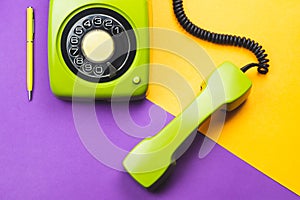 Classic green phone with yellow pen. office background. vintage telephone with phone receiver. old communication technology