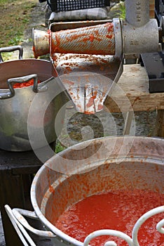 Classic handmade tomato collecting and puree with ancient metal press sauce maker
