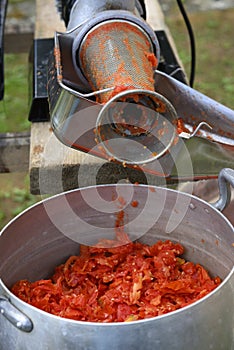 Classic handmade tomato collecting and puree with ancient metal press sauce maker