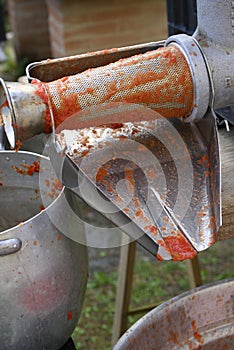 Classic handmade tomato collecting and puree with ancient metal press sauce maker