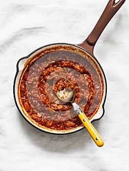 Classic homemade amatriciana tomato sauce in the cooking pan on a light background, top view. Pasta bucatini amatriciana tomato