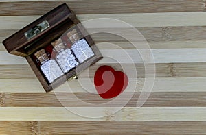 Classic homeopathy for  for healthy heart - Wooden box with homeopath medicine glass bottles of pills and heart on wood background photo