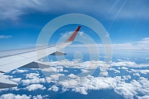Classic image through aircraft window onto wing. Flight view over clouds