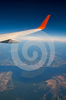 Classic image through aircraft window onto wing. Flight view over Russia