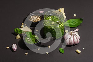 Classic Italian basil pesto sauce in a glass jar. Homemade food, ingredients for traditional recipe