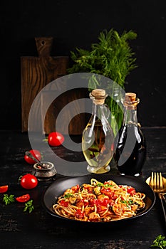 Classic italian pasta spaghetti marinara with mussels and salmon on dark table.