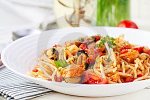 Classic italian pasta spaghetti marinara with mussels and salmon on white table.