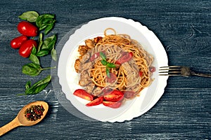 Classic Italian pasta spaghetti in tomato sauce on a plate on a dark background .