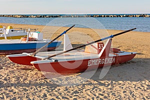 Classic italian rescue ship or rescue rowing catamaran on the sand on beach on the sunset.