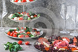 Classic Italian salad Insalata Caprese and a plate with a selection of sausage specialties