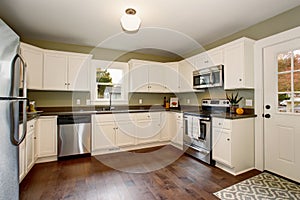 Classic kitchen with green interior paint, and white cabinets.