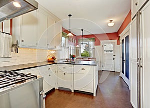 Classic kitchen room with white cabinets, granite counter top and hardwood floor.