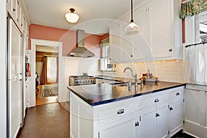 Classic kitchen room with white cabinets, granite counter top and hardwood floor.