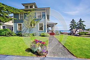 Classic large craftsman old American house exterior in blue tones with well kept garden