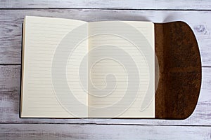 Classic Leather Bound Journal Book Fully Open on a White Barn Board Floor