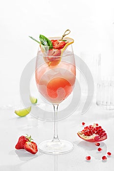 Classic lemonade mix in glass on white background with black currant syrop, mint and strawberry