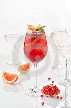 Classic lemonade mix in glass on white background with pomegranade, mint , grapefruit and strawberry