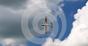 Classic light propeller planes flying in a sunny blue sky with white clouds