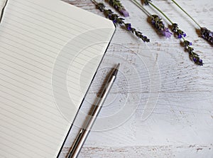 Classic lined notebook and pen in a natural rustic table setting with soft selected focus