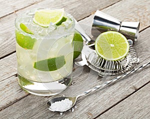 Classic margarita cocktail with salty rim on wooden table