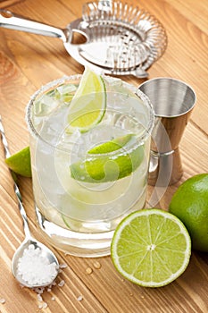 Classic margarita cocktail with salty rim on wooden table