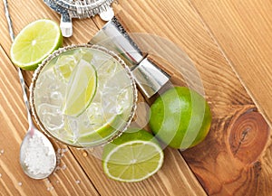 Classic margarita cocktail with salty rim on wooden table