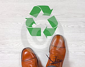 Classic mens shoes with a recycling symbol on the floor