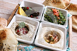 Classic mezza platter with Baba Ganoujm, Turkish Salsa, Labneh, Taboula and Vine leaves served in dish isolated on background top photo