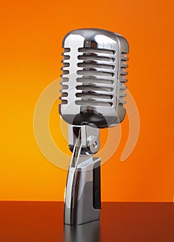 Classic microphone on orange background