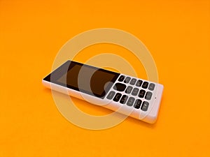 old mobile phone against a bright orange backdrop