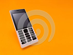 old mobile phone against a bright orange backdrop