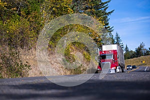 Classic modern red semi truck dry van trailer on autumn road