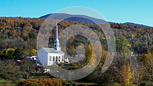 Classic new england white church at stowe and hill with fall foliage