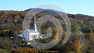 Classic new england white church at stowe and hill with fall foliage
