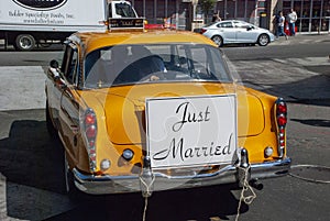 Classic New York Yellow cab vintage car carrying a Just married sign