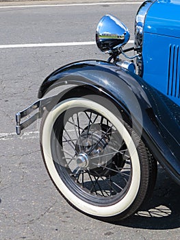 Classic old blue car, detail of the wheel and mudguard.