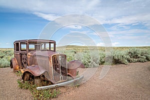 Classic Old Car decays in a meadow.