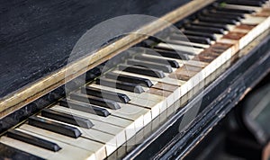 Classic old piano keys. The keyboard of a very old abandoned piano is covered with dust, some keys have dropped, some are absent