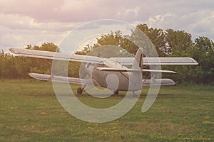 Classic old retro vintage airplane with a propeller at a green airfield