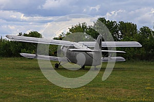 Classic old retro vintage airplane with a propeller at a green airfield