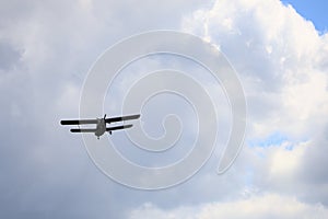 Classic old retro vintage airplane with a propeller in the sky on a background of clouds