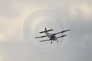 Classic old retro vintage airplane with a propeller in the sky on a background of clouds